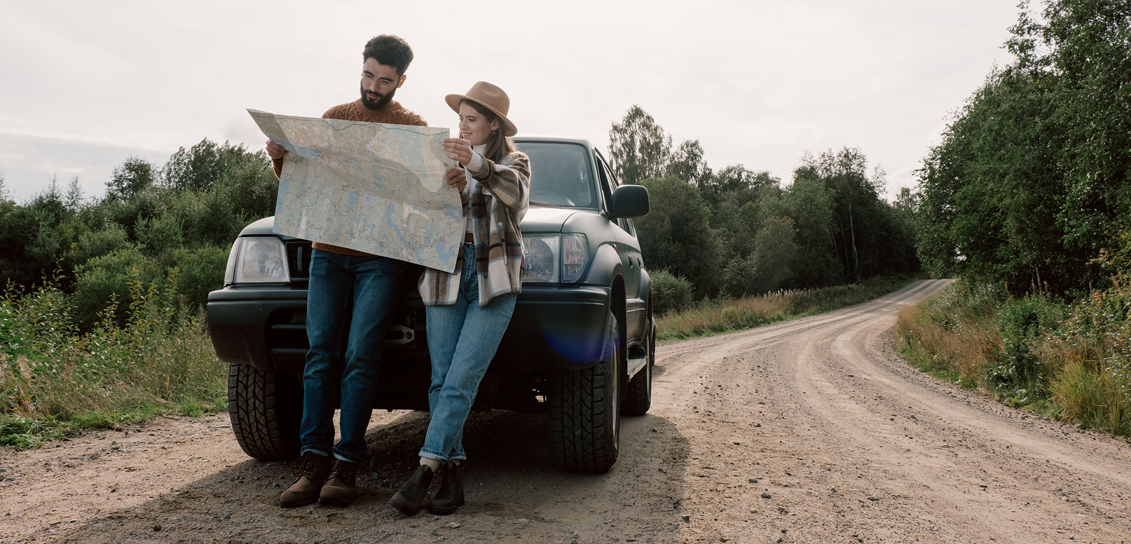 Couple reading a map in front of a car