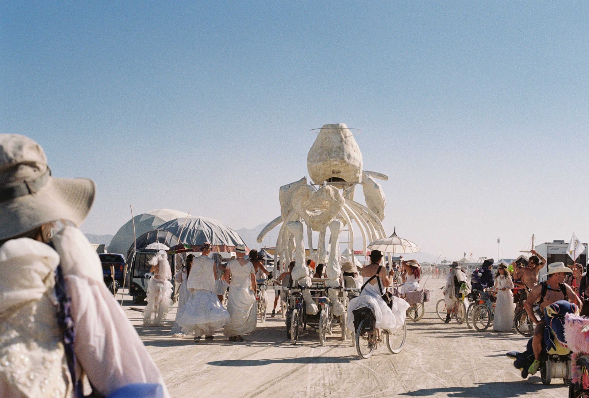 Bezoekers wandelen en fietsen tussen kunstinstallaties op Burning Man in de Black Rock Desert in Nevada
