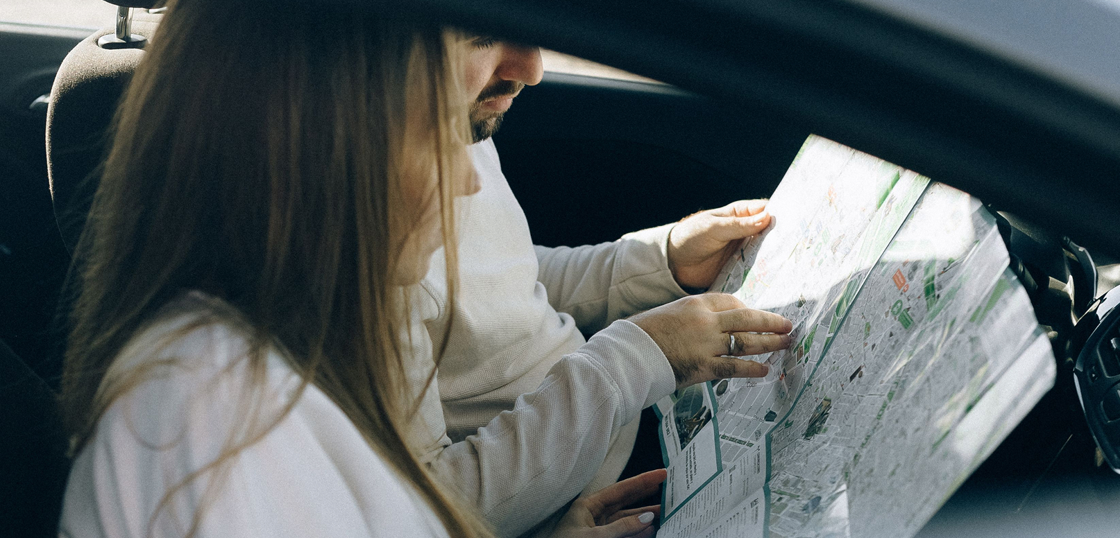 Couple reading a map inside a car