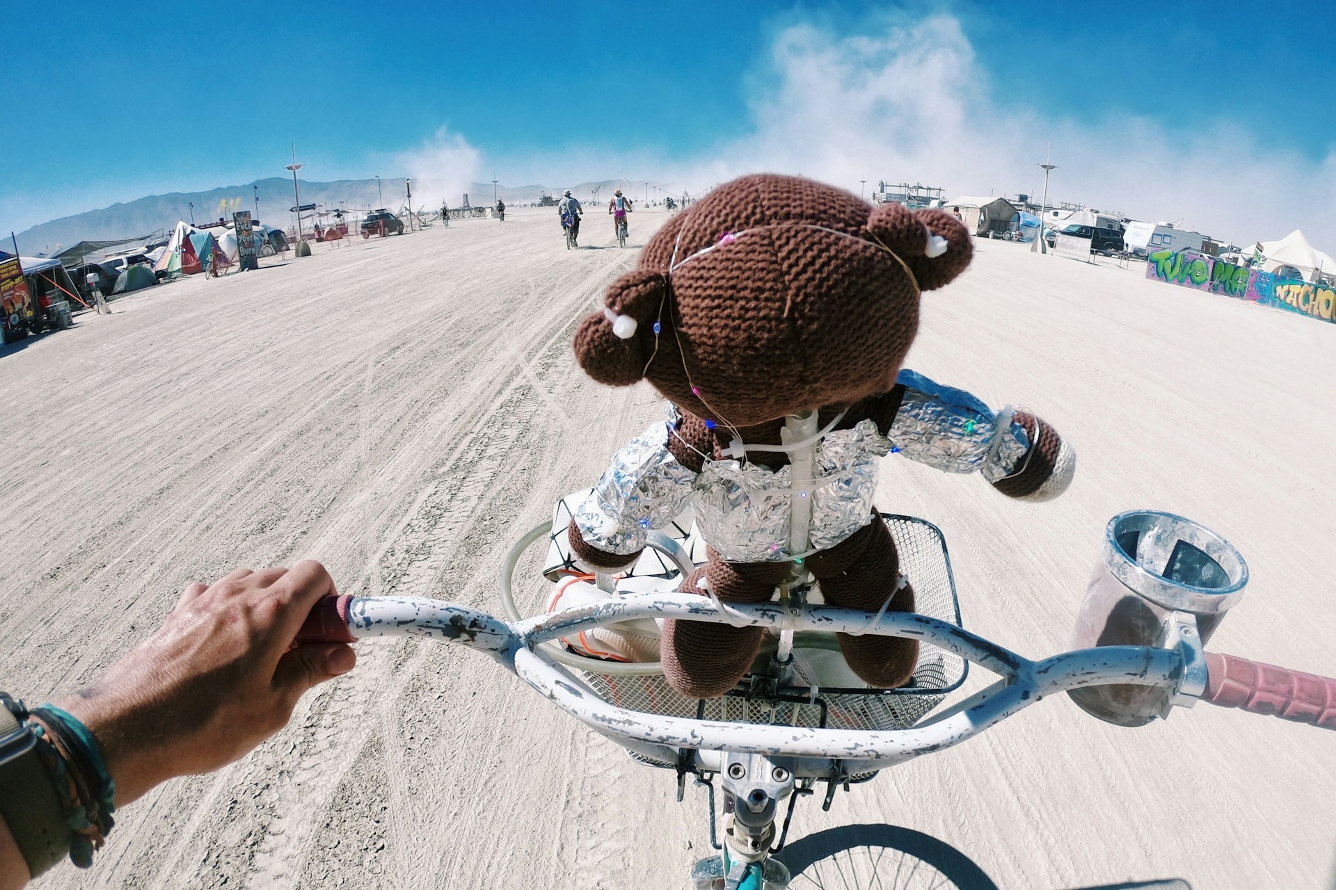 Fietser rijdt over de stoffige playa van Burning Man in de Black Rock Desert