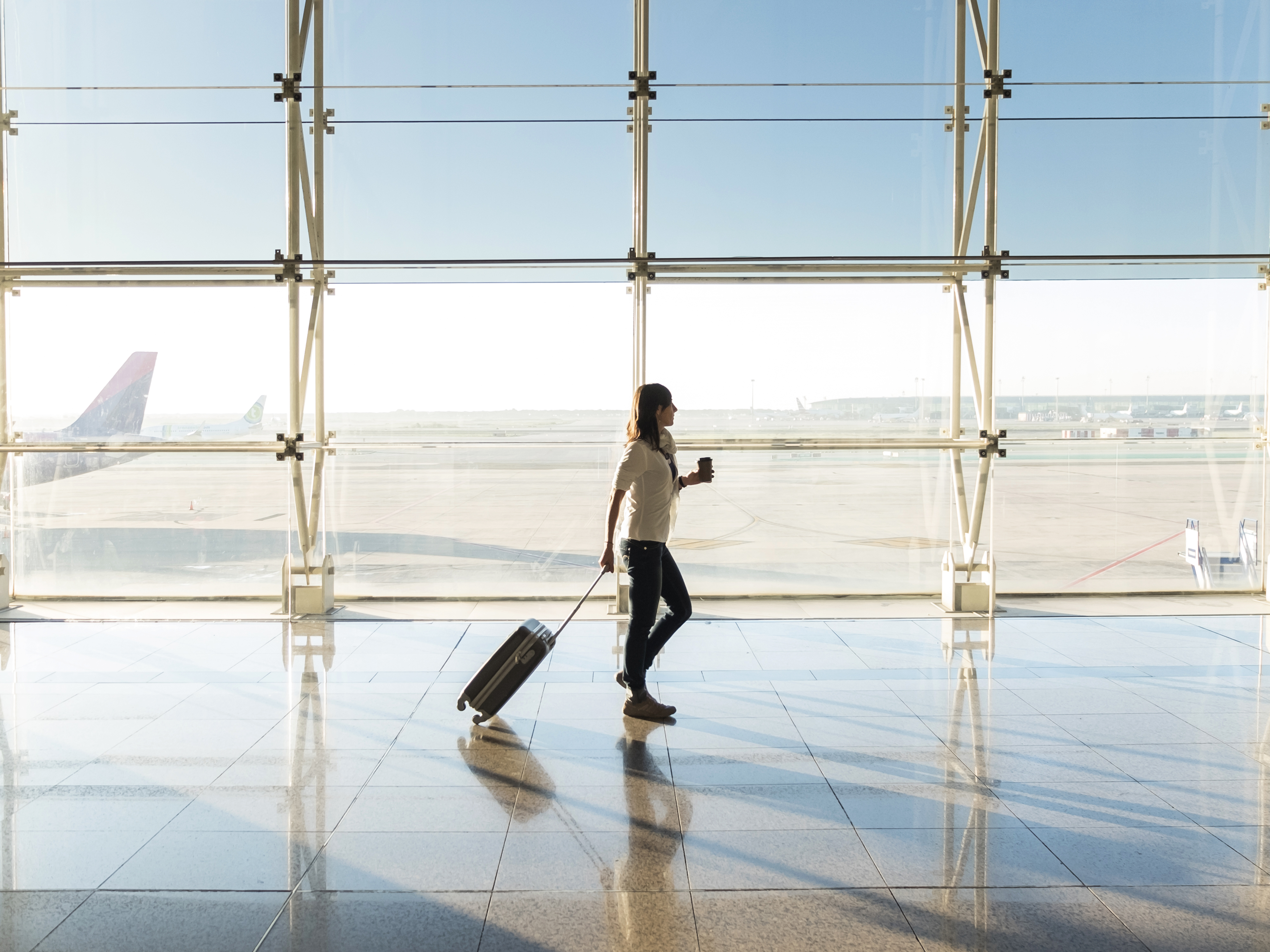 Reisende mit Koffer im Terminal eines Flughafens vor dem Abflug