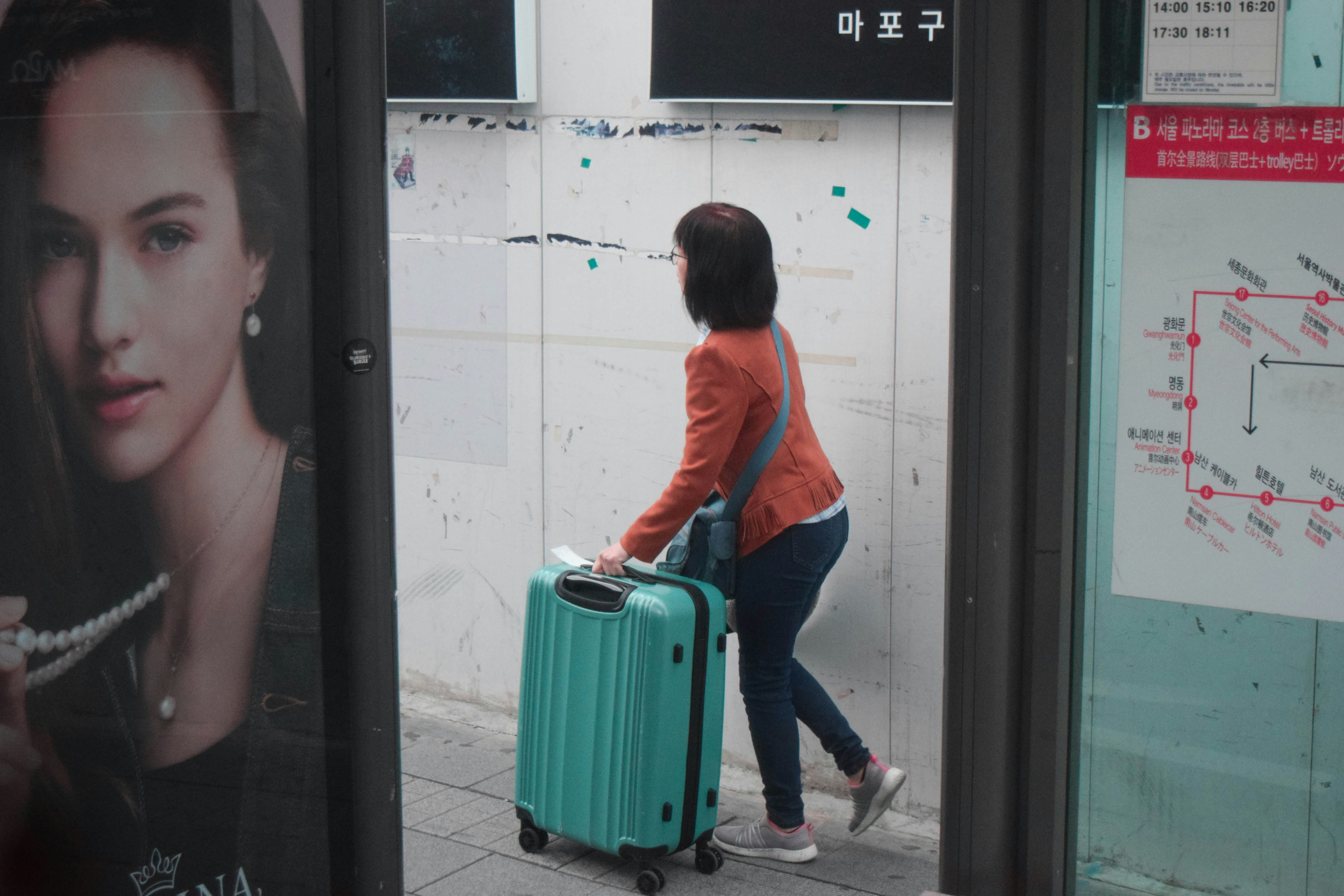 Person mit Rollkoffer auf dem Weg zum Flughafen für den bevorstehenden Flug