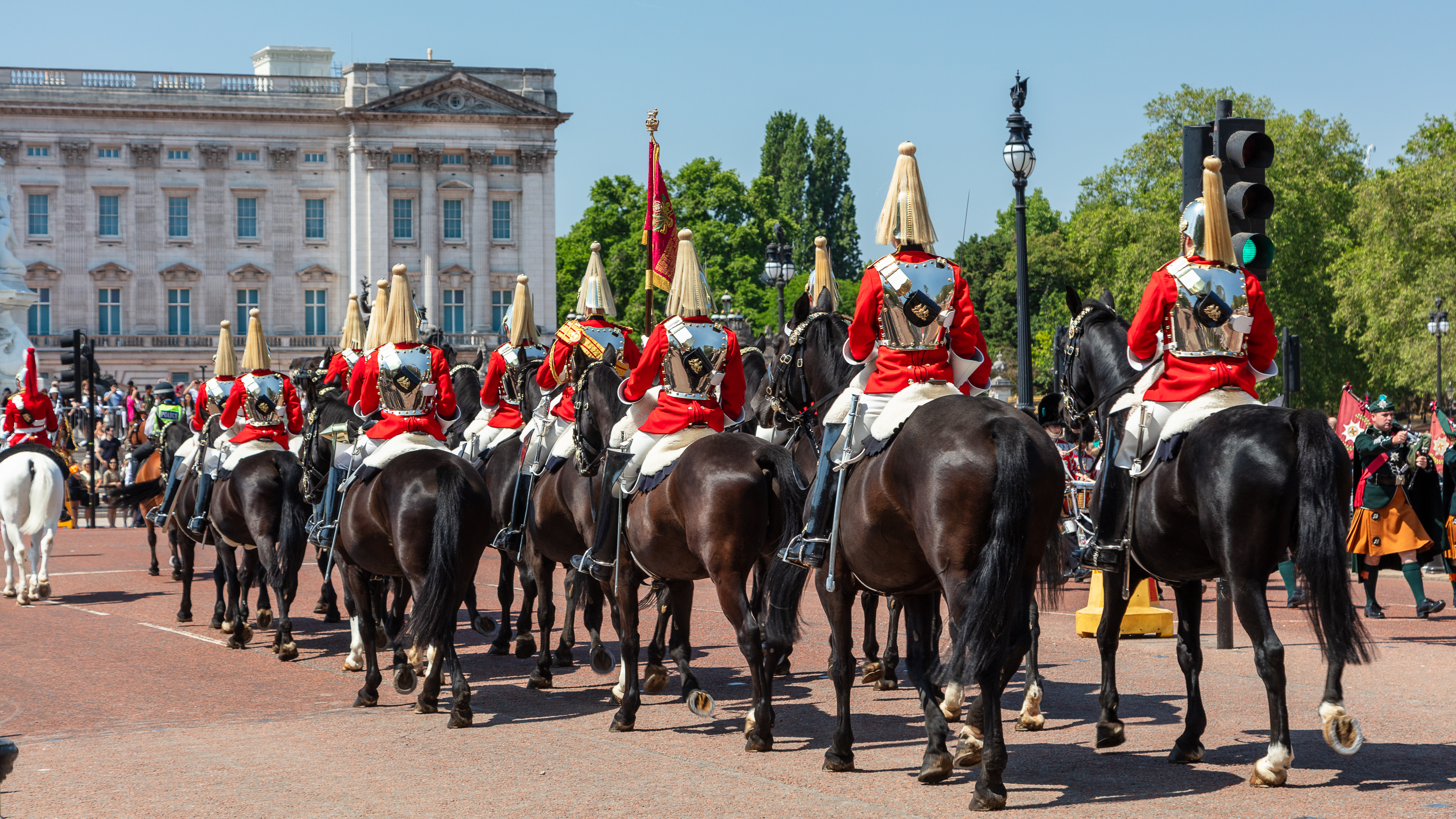 Horse riders in ceremonial clothing riding heading toward Buckingham Palace London