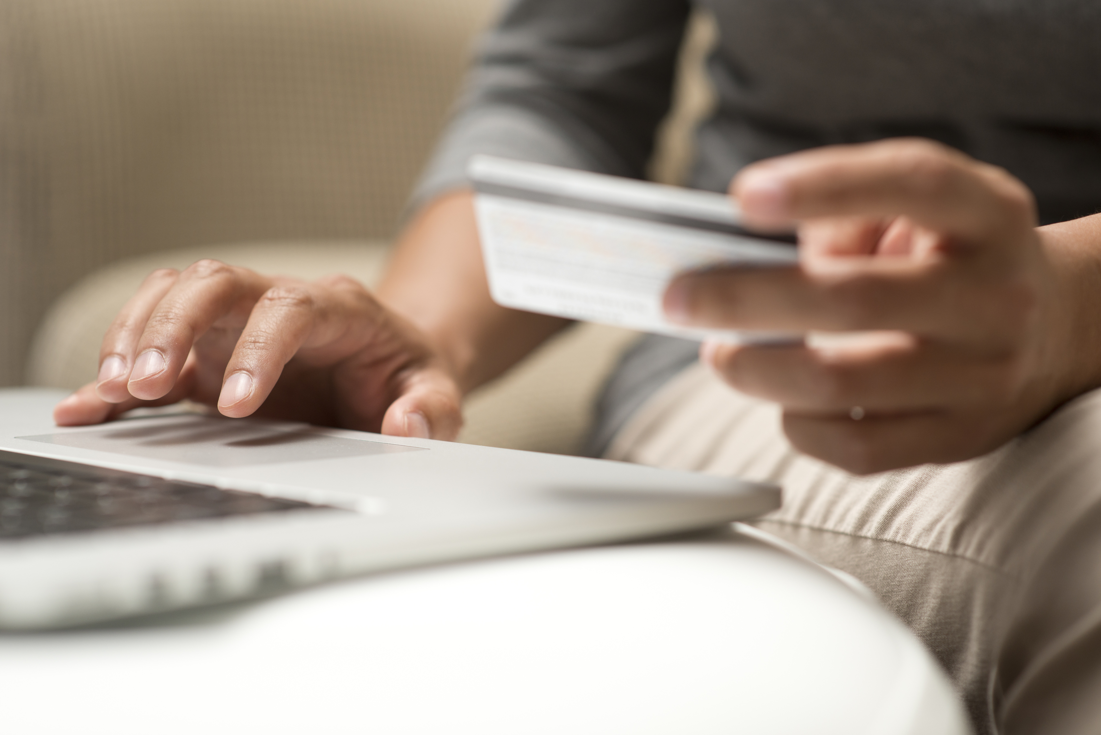 Person reading their credit card while using a laptop